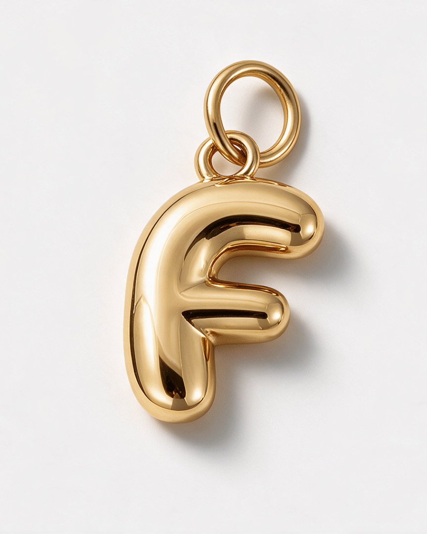 A polished gold letter 'F' pendant charm with a smooth, rounded, balloon-like organic shape and a top loop, shown on a clean white background.