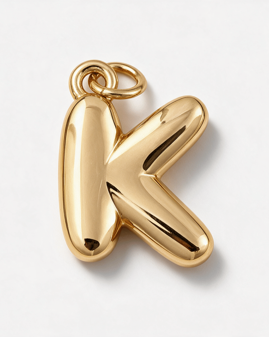 A polished gold initial pendant shaped like the letter 'K', shown on a clean white background.