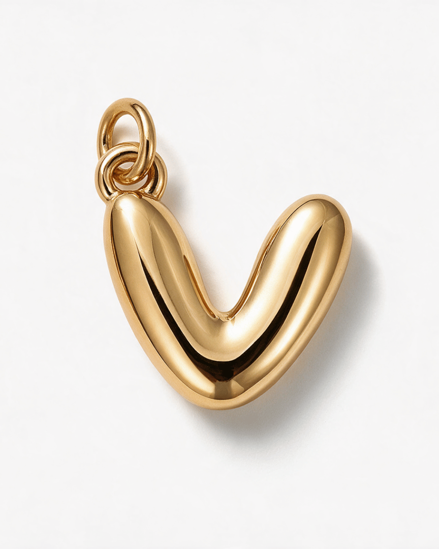 A polished gold pendant shaped like a stylized lowercase 'v' or rounded abstract letter, shown on a clean white background with a soft shadow.