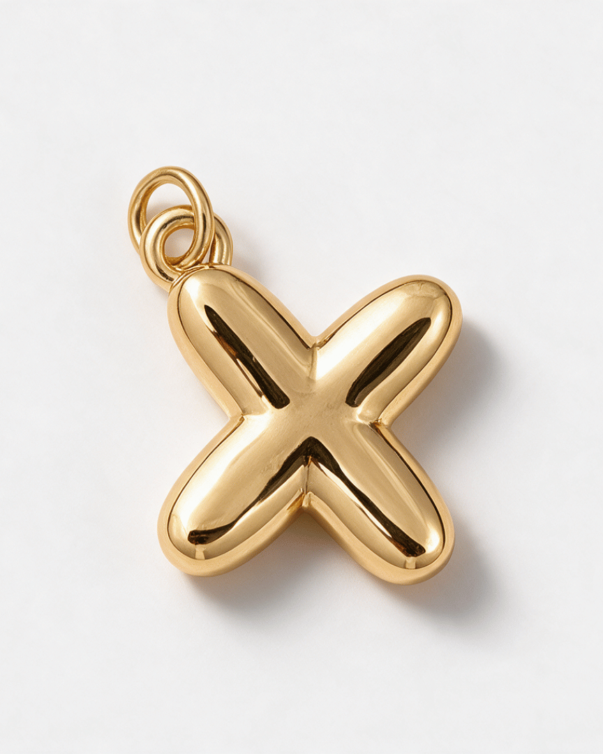 A polished gold pendant shaped like a stylized letter 'X' with a hanging loop at the top, photographed on a clean white background.