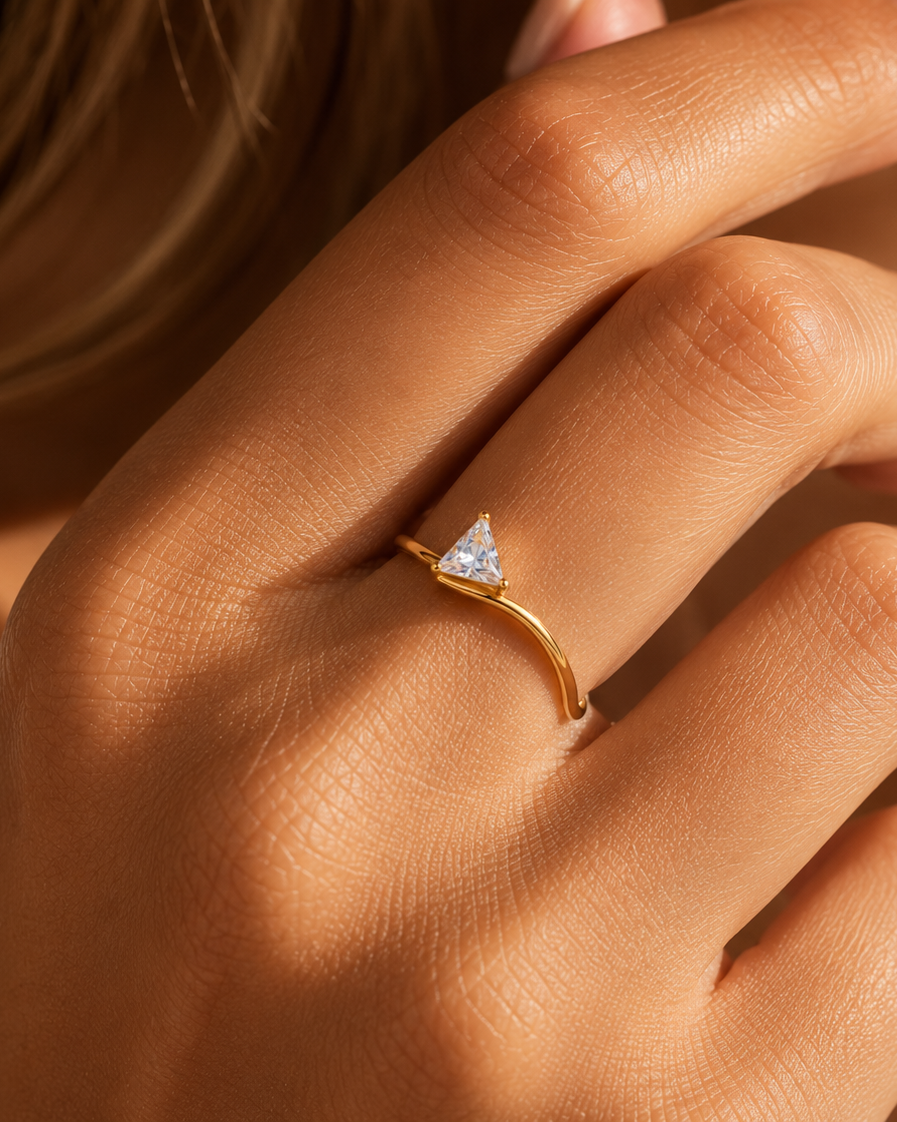 Gold ring with a triangular diamond on a hand