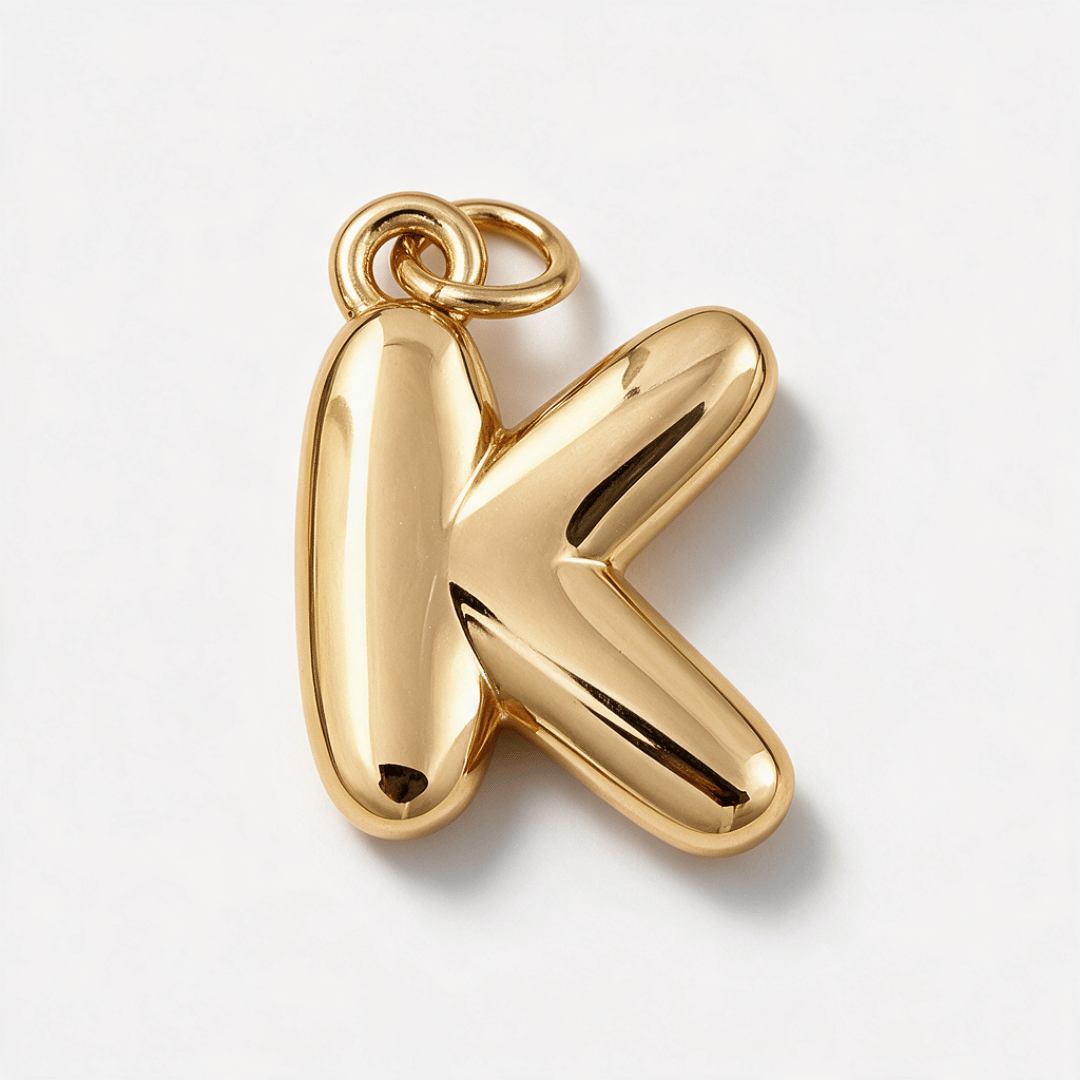 A polished gold initial pendant shaped like the letter 'K', shown on a clean white background.
